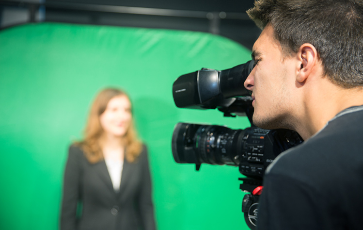 Student with camera and green screen