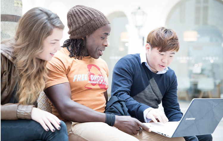 Students conferring at a laptop