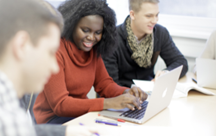 Students collaborate at a laptop