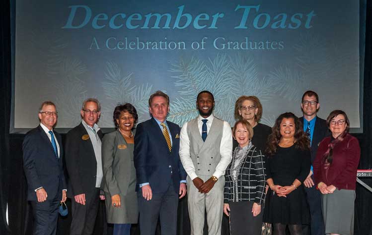 Chancellor Stroble and Neal Richardson pose with President Schuster, deans and Academic Affairs staff during the annual 2021 December Toast. 