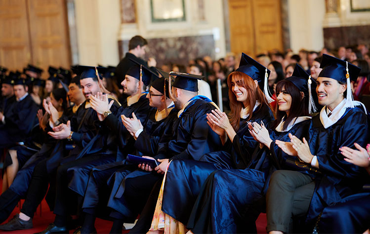 Webster Vienna graduates clap at the 2023 commencement ceremony.