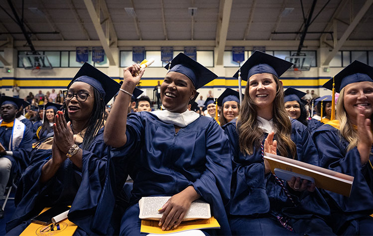 Graduates celebrate after turning their tassels in a ceremony in the Grant Gym.