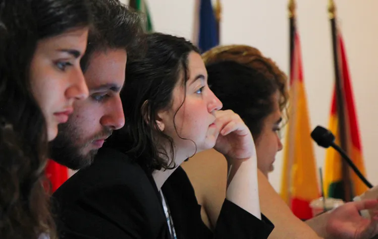 Four students' side profiles are photographed as they listen to the presentation at the Webster Athens Cultural Center.