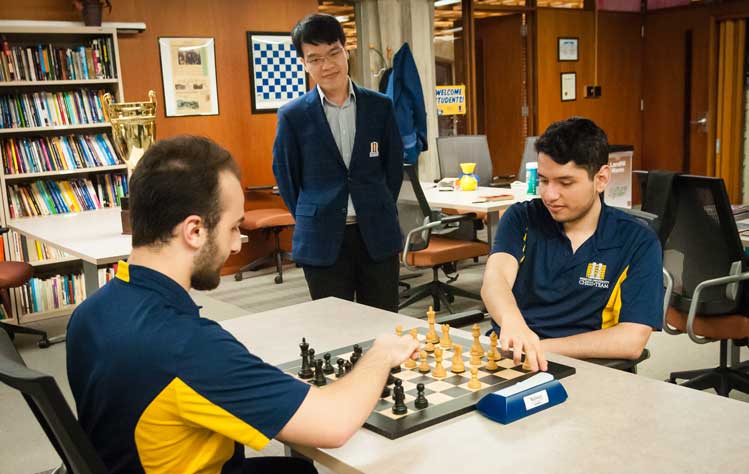 Chess Coach Liem Le watches as two chess team members practice for an upcoming tournament in 2023.