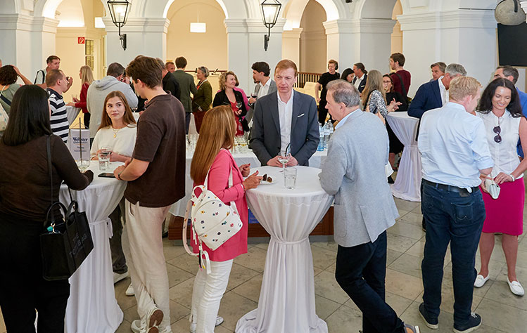 Attendees stand around tables at Webster Vienna Private University