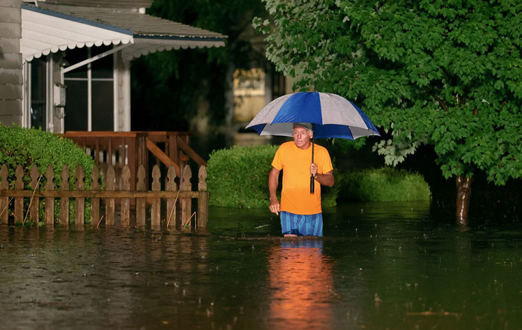 A man navigates a flooded street in the St. Louis region.