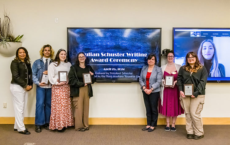 Julian Schuster award winners hold their plaques at the end of the ceremony.