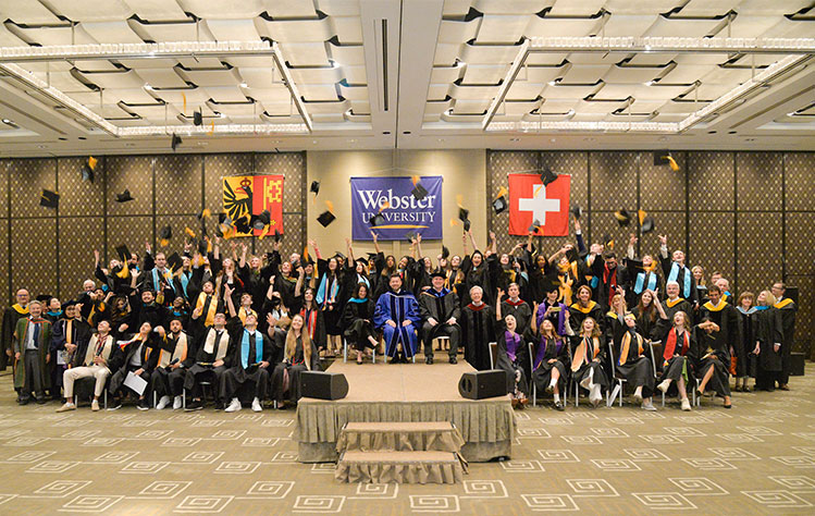 The Webster Geneva Class of 2023 tosses their caps during a group class photo.