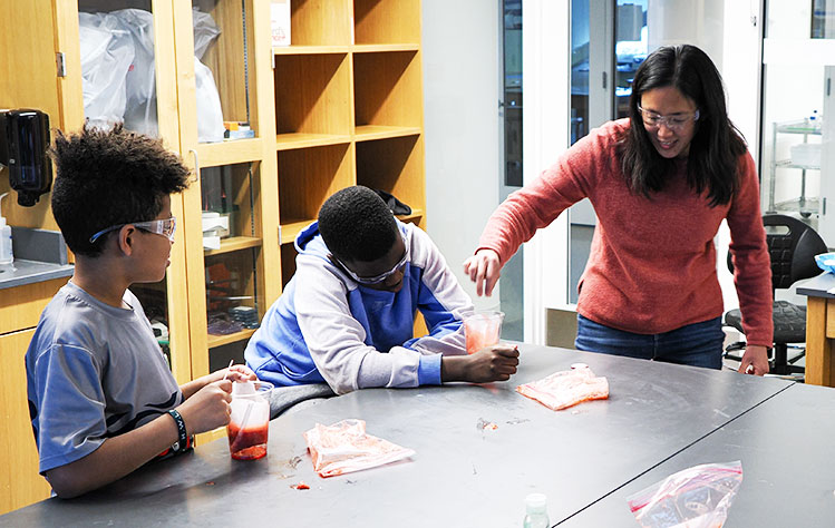 Professor Mary Lai Preuss helps fourth graders extract DNA from a strawberry.