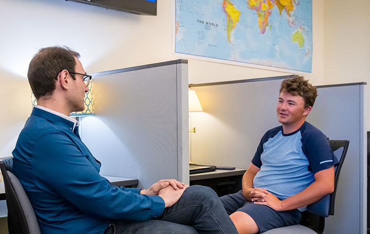 Professor Dani Belo talks with Webster student Joshua Hayes about his research project.