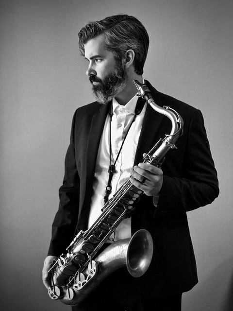 Black and white of Bennett Wood holding saxophone