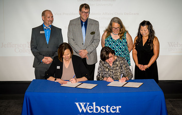 Officials from Webster University and Jefferson College sign an agreement