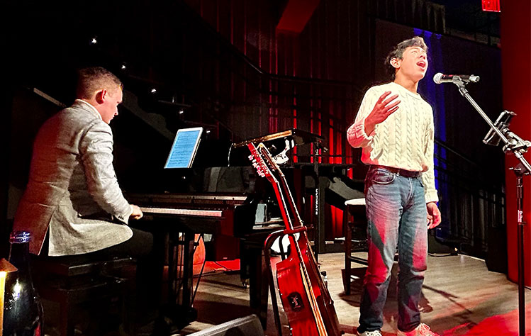 Jones sings at the cabaret while Jacobs accompanies him on piano. 