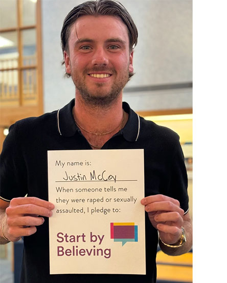 Justin McCoy holds his “Start by Believing” pledge.