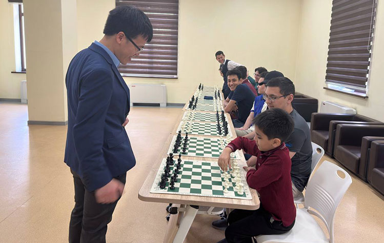Le simultaneously plays 10 games of chess at Webster University Tashkent.