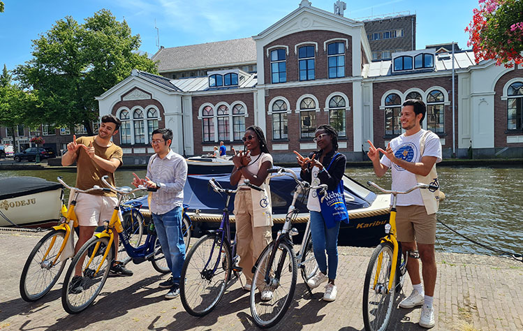 A group of students on bicycles in front of Webster's Leiden campus.