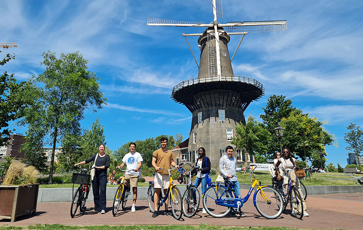 Students abroad at Webster Leiden in front of an old windmill in Leiden.