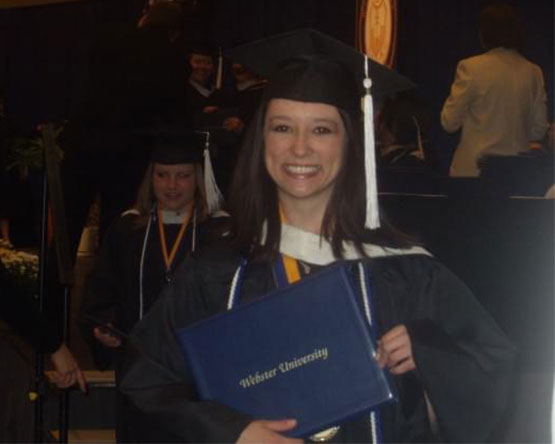 McInnis holds her diploma while wearing her cap and gown at her graduation ceremony.