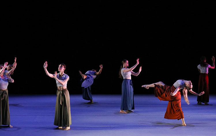 Dancers pose around the stage in various positions.