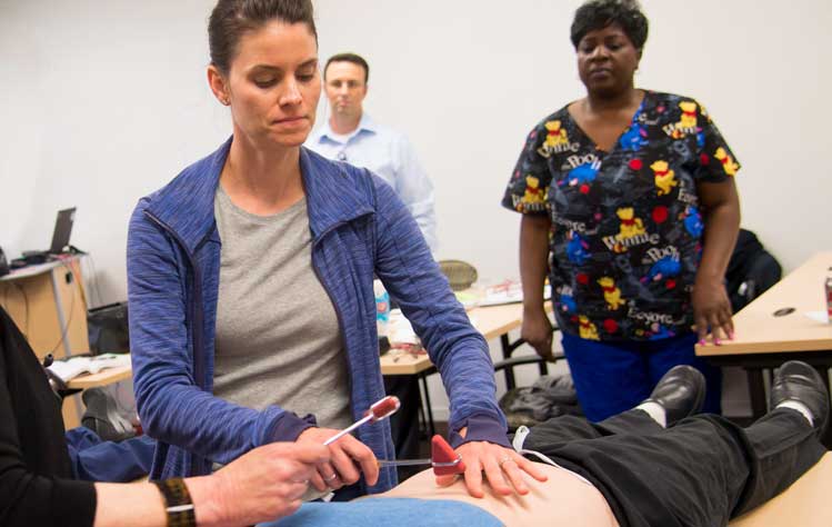 A graduate nursing student learns how to take health assessments.