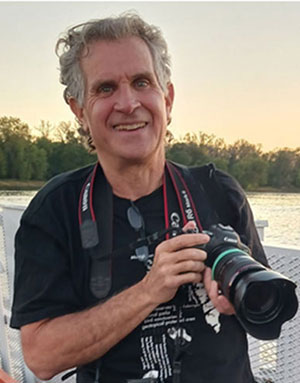 Headshot of Randall Hyman holding a camera.