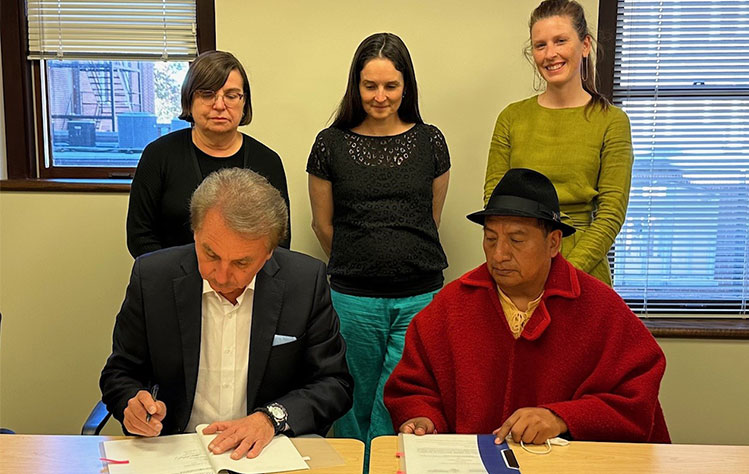 Schuster and Chicaiza sign the memorium of understanding for a partnership agreement. Nancy Hellerud, Webster University vice president for academic affairs, Hill, and Hannah Verity, director of global program development at Webster University, look on.