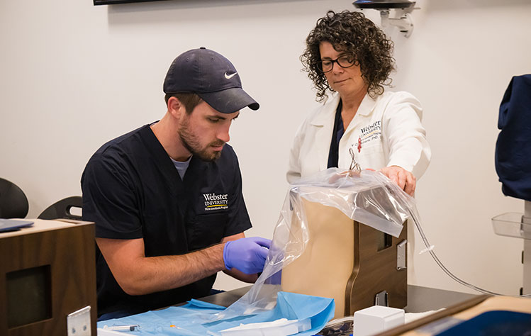 A Webster University professor guides a Doctor of Nurse Anesthesia student.