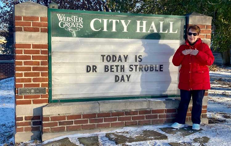 Chancellor Stroble stands next to a sign that declares the day to be named after her