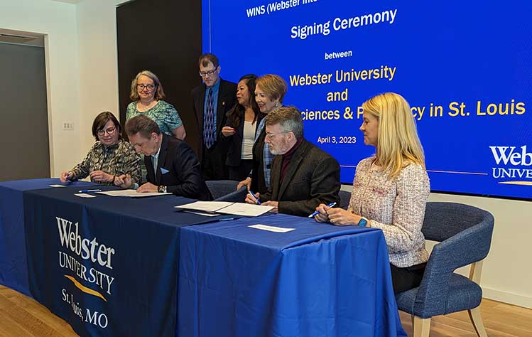 Representatives of Webster University and UHSP sign the agreement during a ceremony on April 3, 2023.