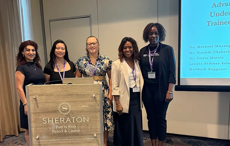 The five Webster WICS faculty stand in front of their presentation after giving it in Puerto Rico.